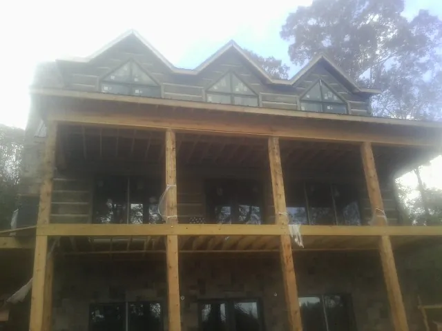 Dormers and porch framing on a large log home under construction — Roof Coating work by our crew in Gamaliel