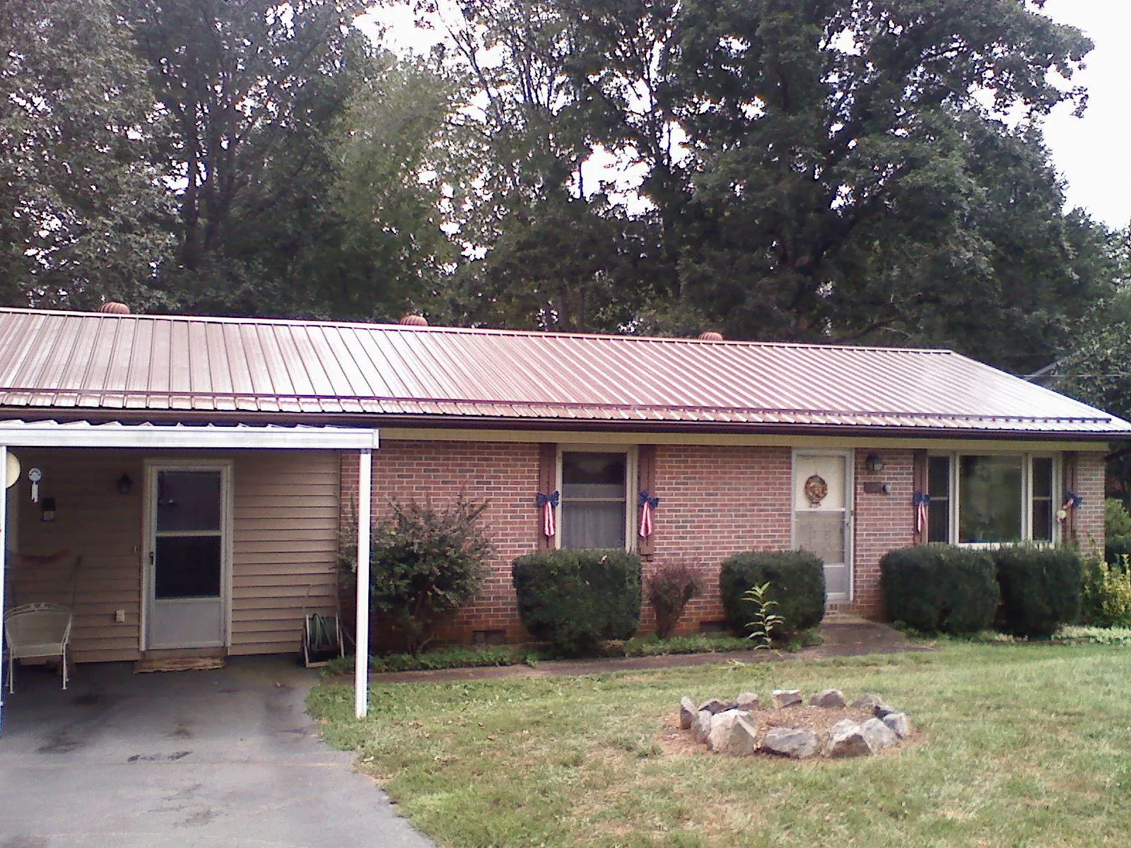 Bronze metal roof and carport on a brick ranch home — Roof Repair work by our crew in Gamaliel