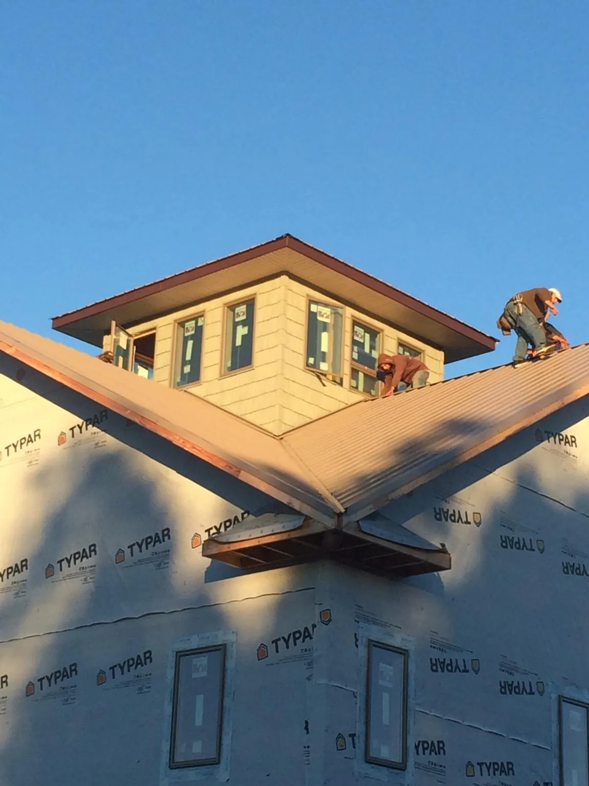 Roofers working around a rooftop cupola on a new metal roof at sunset — Roof Waterproofing in Gamaliel by Roofing Brothers
